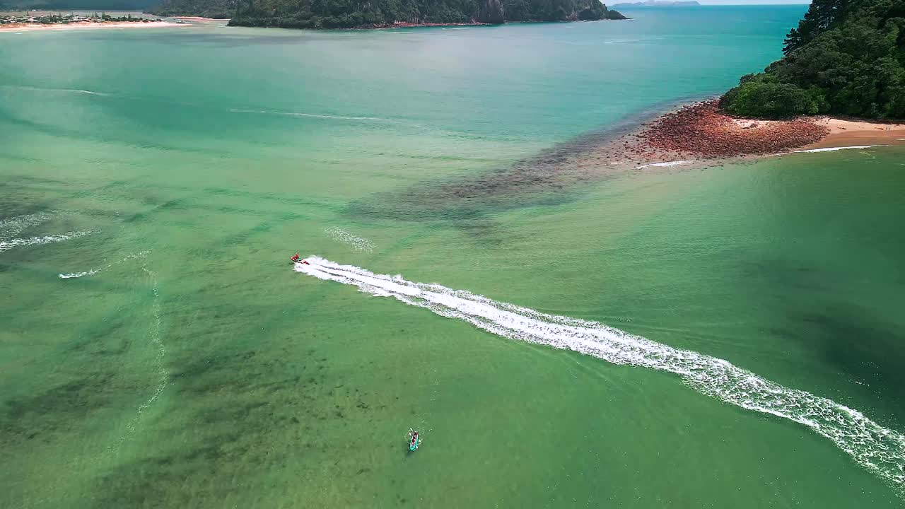 뉴질랜드 코로만델 반도를 따라 여름날을 즐기는 보트와 카약