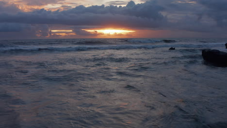 Retreating-view-of-waves-on-the-ocean-during-sunset.-Sea-waves-on-a-rocky-shore-in-beautiful-warm-evening-light