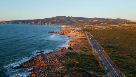 rocky sea coast road at sunset sunlight. aerial view transport riding highway.