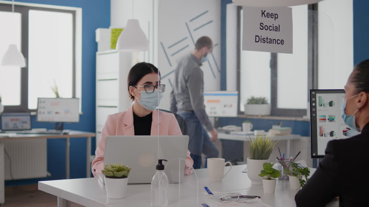 마스크를 착용한 비즈니스 팀이 마케팅 프로젝트를 계획하고 있습니다.