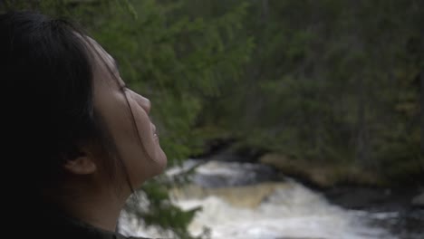 Girl-looking-at-the-forest-besides-a-river