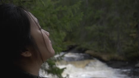 girl looking at the forest besides a river