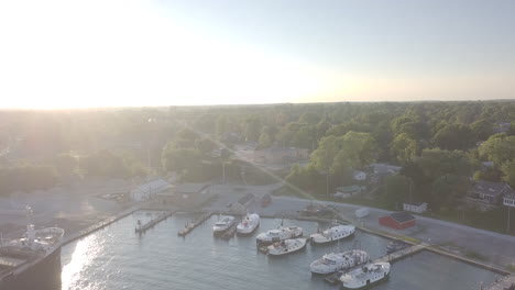 yachts docked at the sea port with lush trees in kingsville, ontario, canada on a sunny day - aerial drone shot