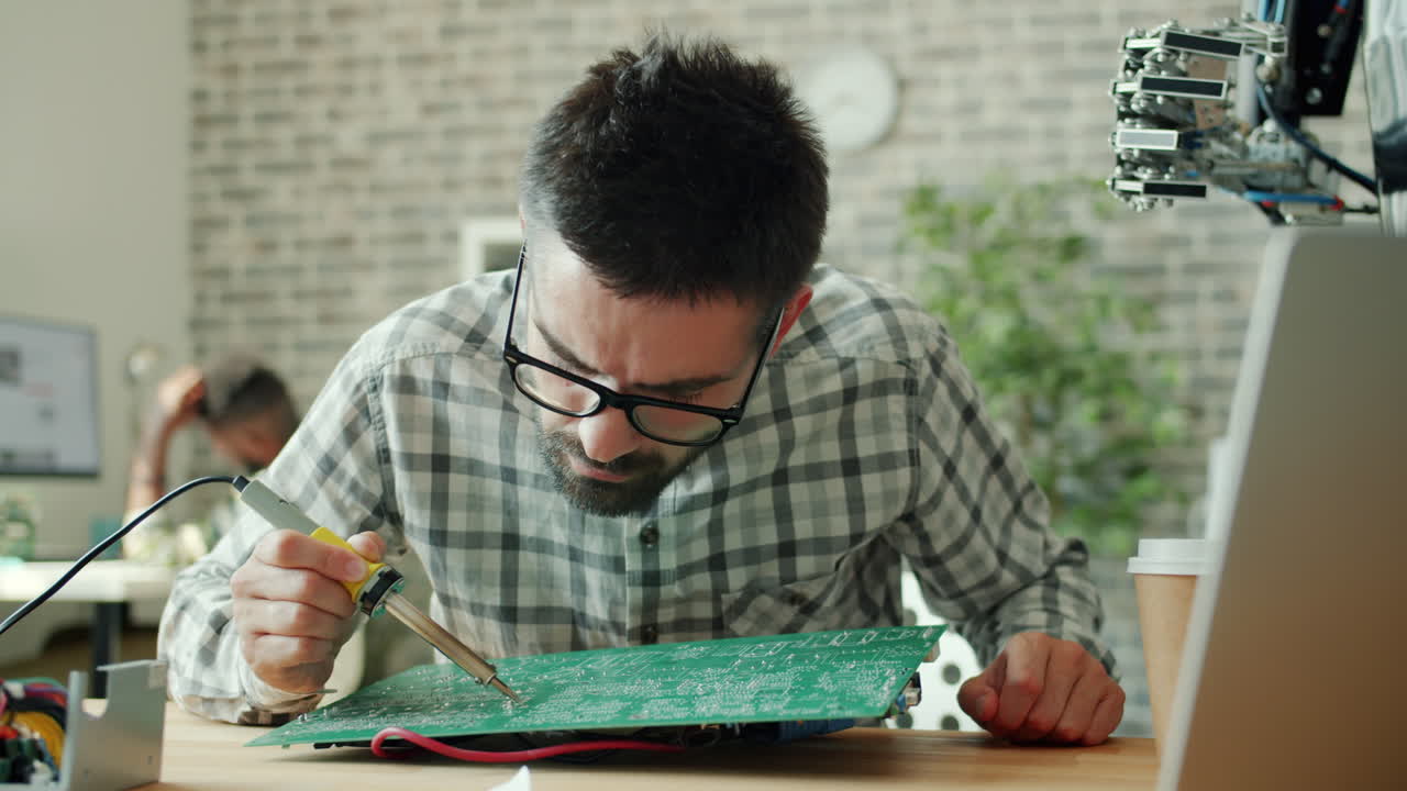 Technician Soldering Circuit Board in a Modern Workshop