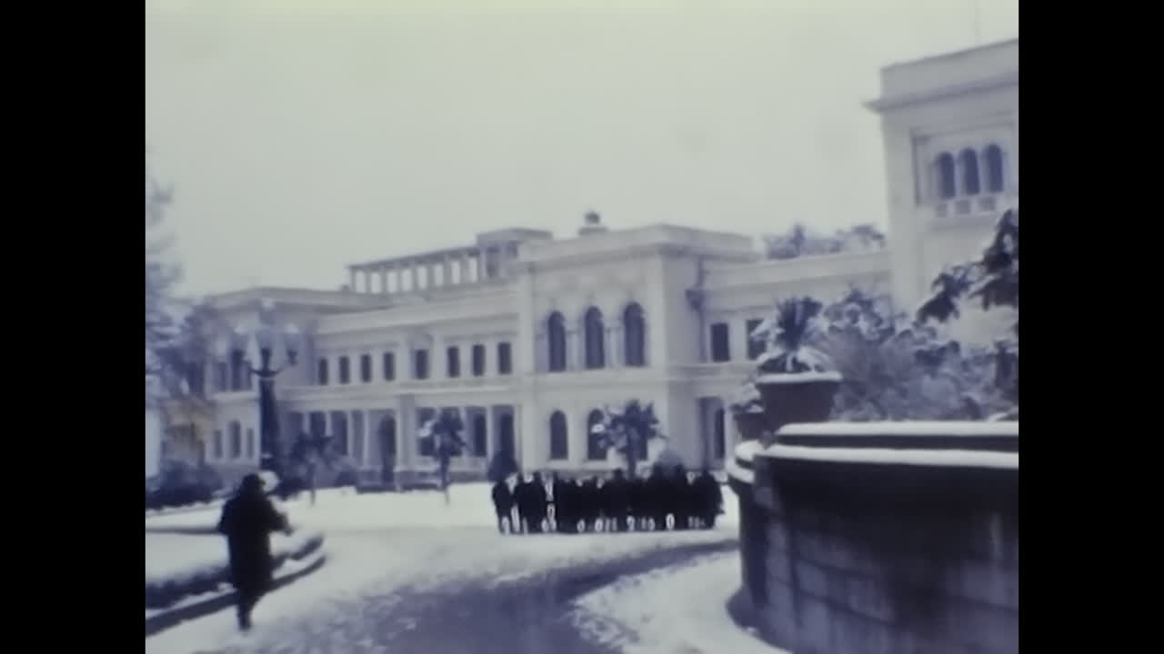 Group of People Standing in Front of a Soviet Building. CIRCA USSR 1970: A snapshot of Soviet people standing together in front of a historic building in the USSR.