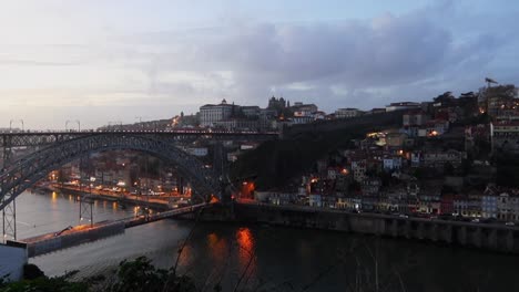 High-angle-tilt-down-of-beautiful-Porto-suburb-with-Dom-Luis-I-Bridge-at-dusk