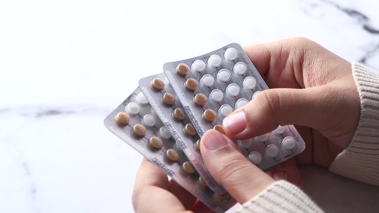 Mujer sosteniendo píldoras anticonceptivas