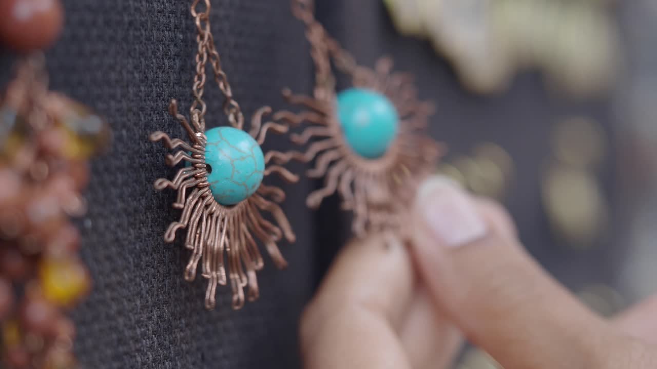Close-Up of Hand Touching Handmade Turquoise and Copper Earrings