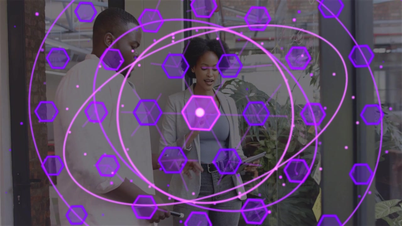 Woman tapping tablet with colleague in tech demo, generating growing purple AR hex orbits near hand