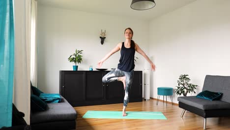 young girl doing her workout at home in the living room - yoga exercise