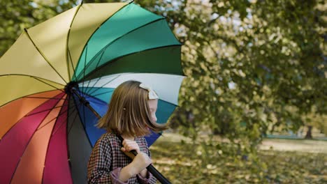 Handheld-view-of-happy-girl-with-umbrella-in-the-fall-season