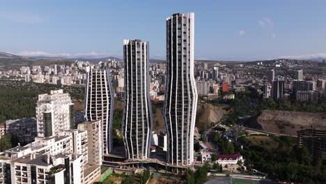 orbiting drone shot above alliance highline, modern skyscrapers tbilisi, georgia