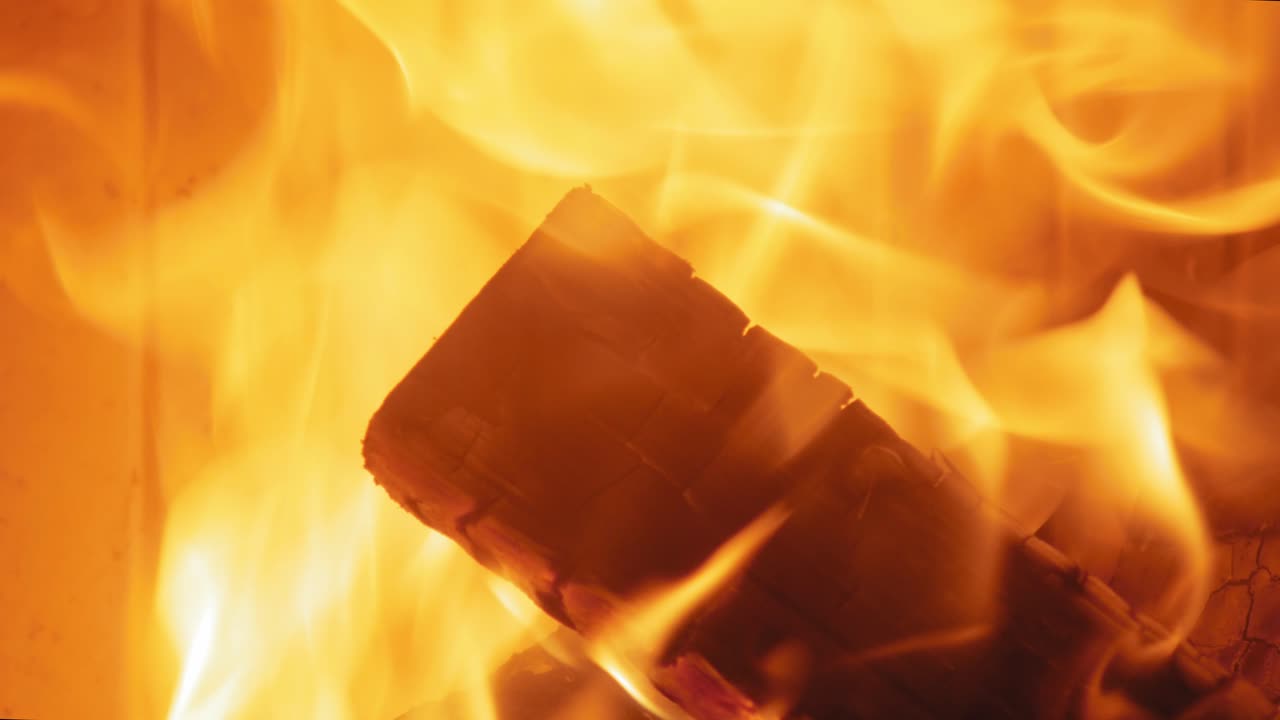 나무 통나무에 있는 벽난로에서 타는 불꽃