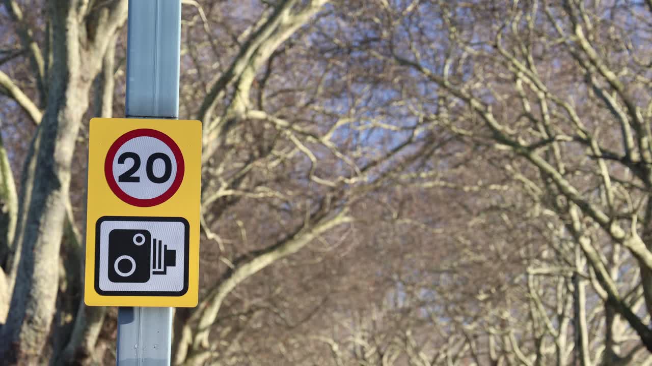 Speed limit and traffic camera sign, establisher blurred background