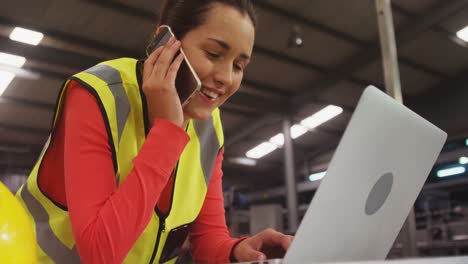 Female-superior-using-laptop-while-talking-on-mobile-phone