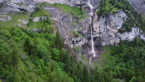 catarata de almenbach que fluye entre pinos y rocas alpinas en kandersteg, suiza, desde el aire