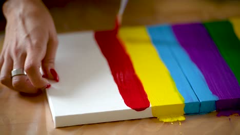 a woman painting colorful stripes on a canvas