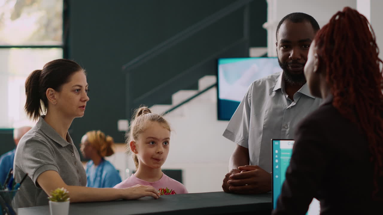 Diverse people asking receptionist about appointment with medic