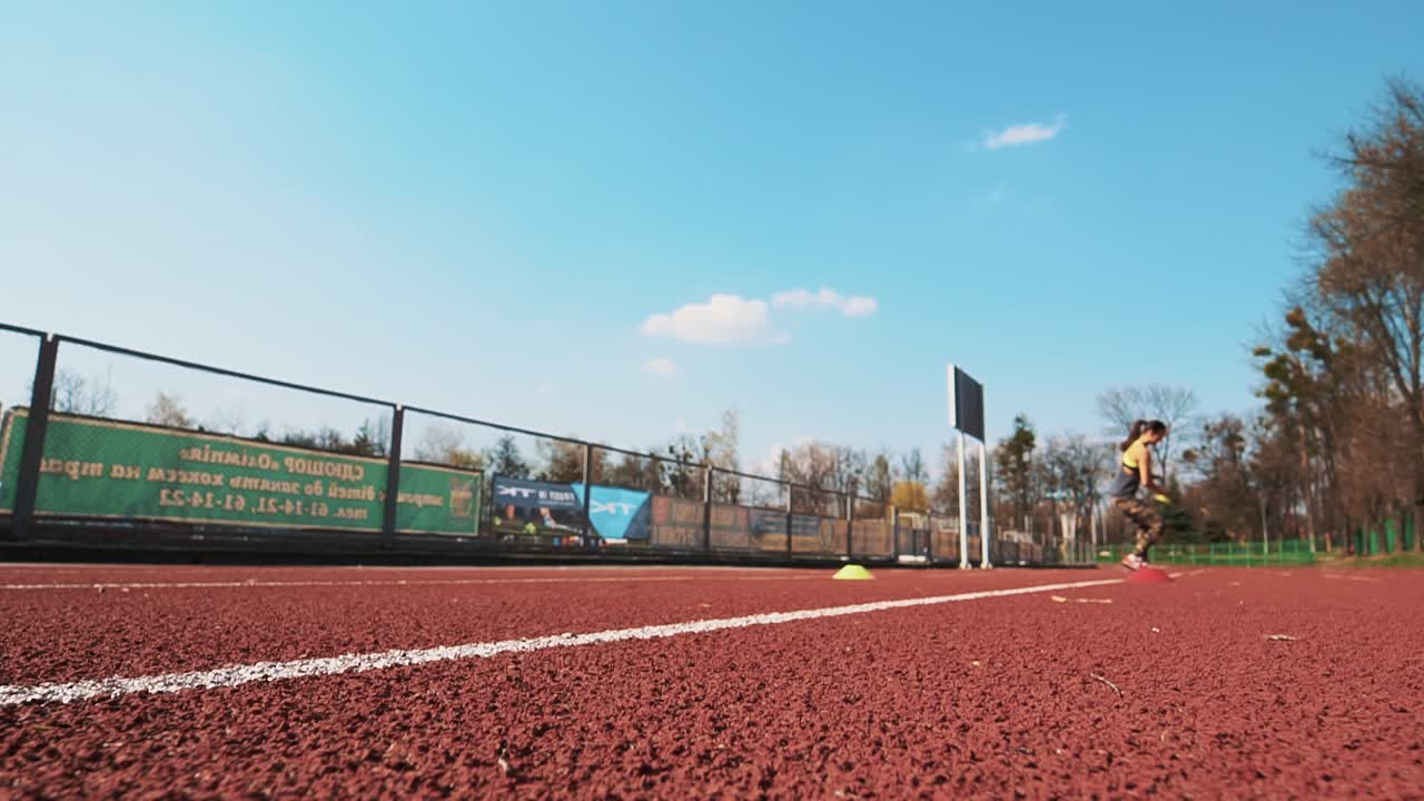 Summer outdoors training. Athletic woman running on track. Beautiful body.