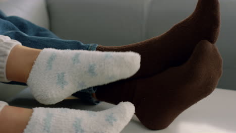 couple wearing socks legs closeup. playful spouse watching tv at cozy home.