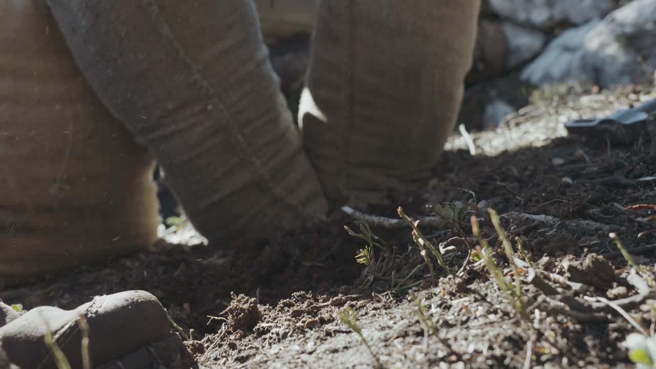 un hombre excavando en la tierra y lleva zapatos en el pie, bolsa de arena en el fondo, ww1, trincheras