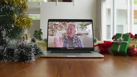 Hombre-Caucásico-Sonriente-Saludando-En-Una-Videollamada-Navideña-En-Una-Computadora-Portátil