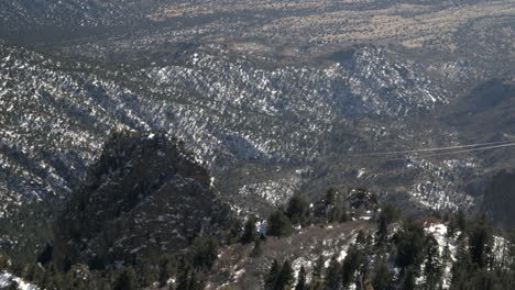 aerial tramway car travels downhill through massive mountains with snow, 4k