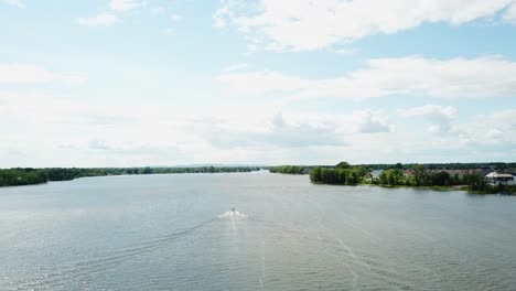 Tiro-De-Drone-De-Lancha-Rápida-En-Un-Lago-Con-Vista-Despejada-Del-Cielo