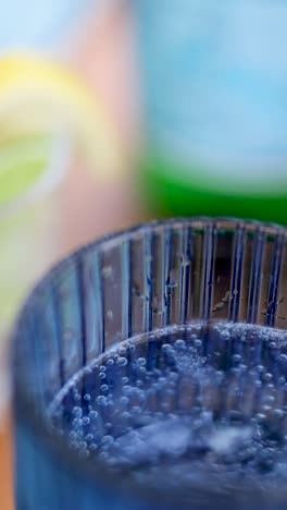 primer plano de refresco burbujeante en un vaso con guarnición de limón, destacando texturas refrescantes y colores vibrantes