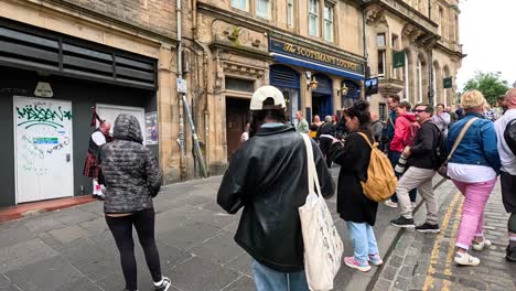 crowd gathers for a street performance in edinburgh