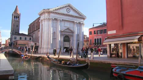 Pedestrians-and-boats-on-a-quiet-canal-in-Venice-Italy