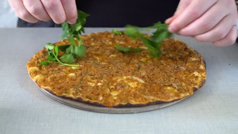 un hombre comiendo pizza tradicional turca (lahmacun) en un restaurante.