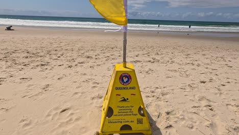 lifeguard flag and beachgoers at currumbin beach