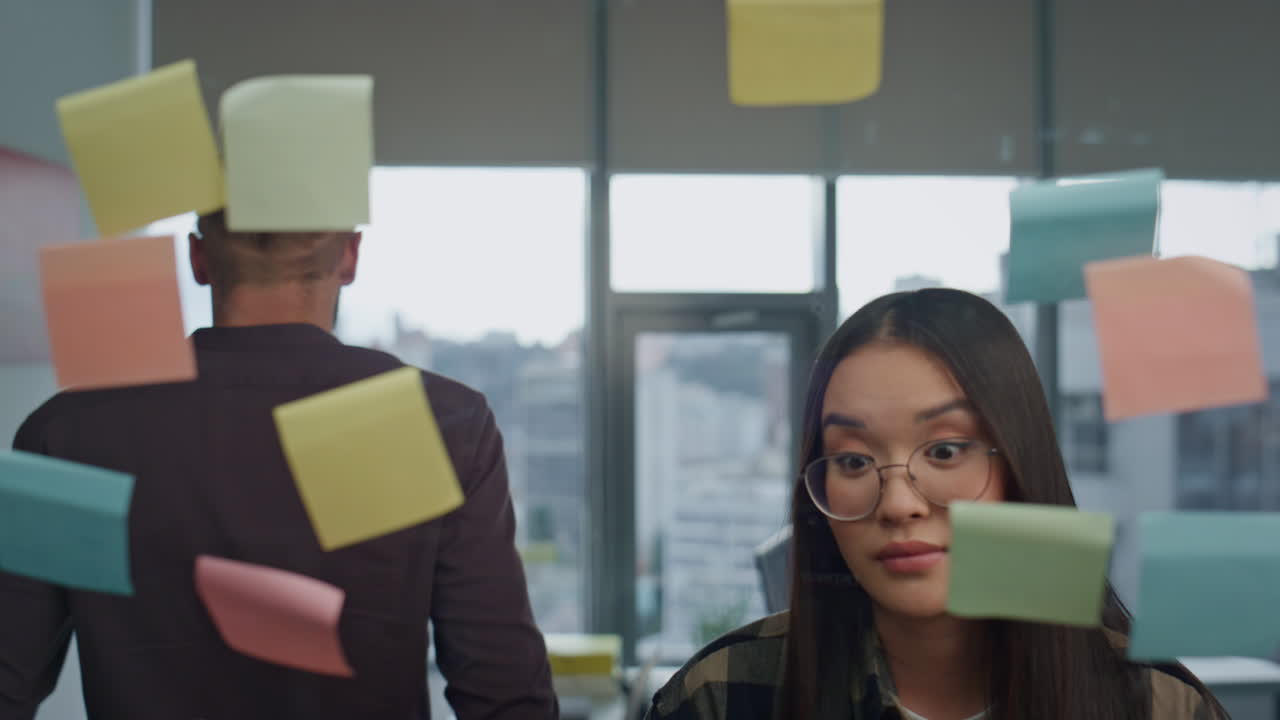 Nervous team arguing at stickers wall office closeup. Angry man tearing notes