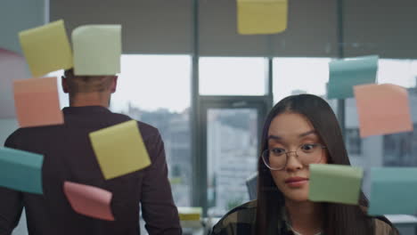 nervous team arguing at stickers wall office closeup. angry man tearing notes