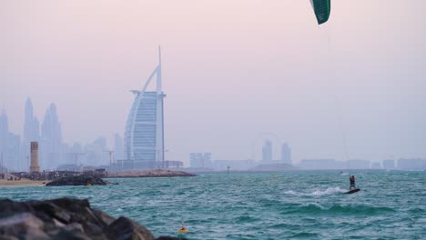 Kite-Surf-En-El-Agua-En-La-Playa-De-Dubai-Con-El-Hotel-Burj-Al-Arab-En-Segundo-Plano-En-Los-Emiratos-árabes-Unidos