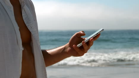 Un-Hombre-Guapo-Vestido-De-Blanco-Usando-Un-Teléfono-Inteligente