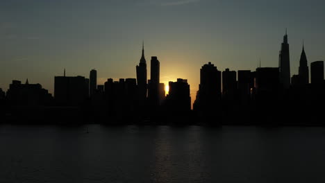 Sehr-Langsame-Kippfahrt-über-Das-Seltene-Manhattanhenge-phänomen-Mit-Einem-Sonnenstrahl,-Der-Zwischen-Gebäuden-Auftaucht-Und-Dann-Wieder-Verschwindet