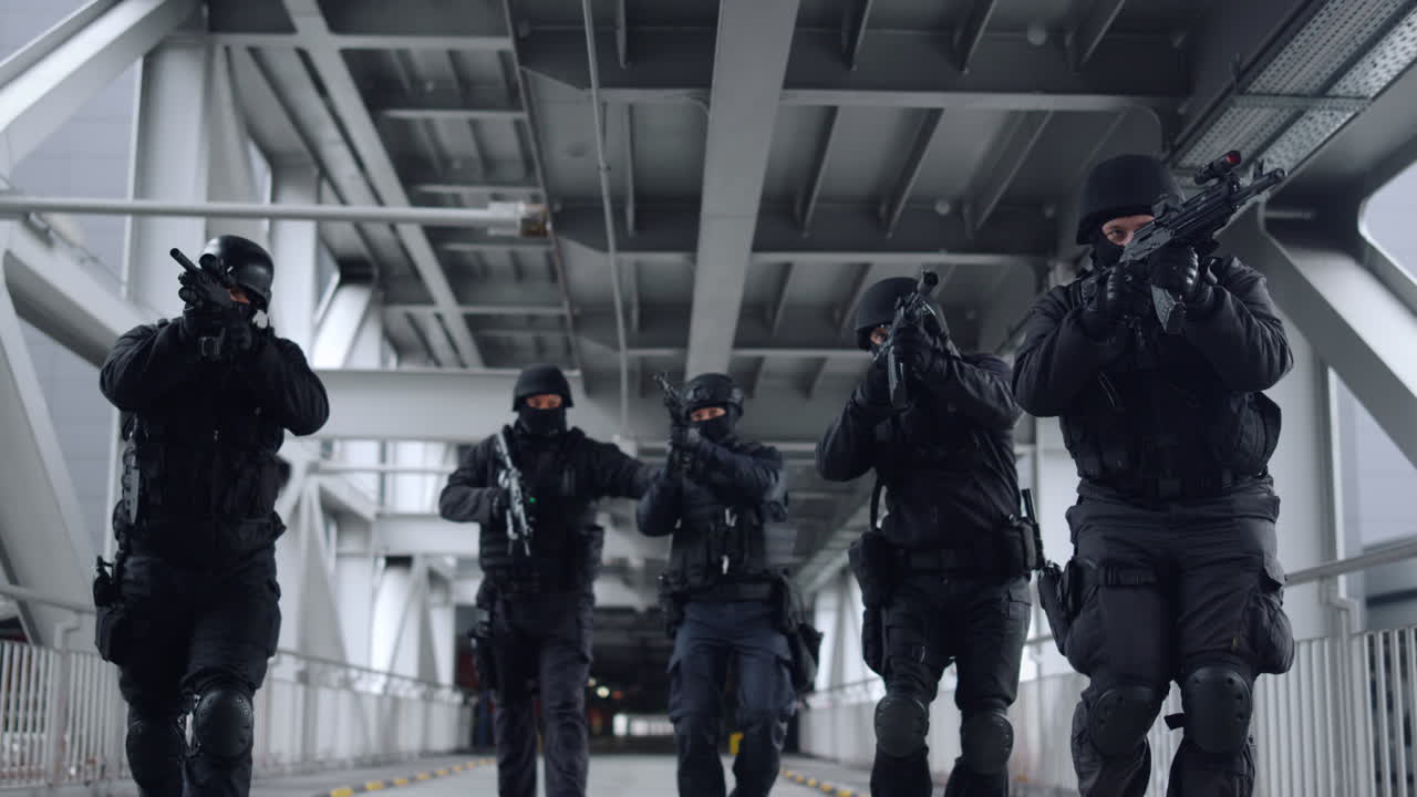 SWAT police officers covering each other with assault rifles during operation