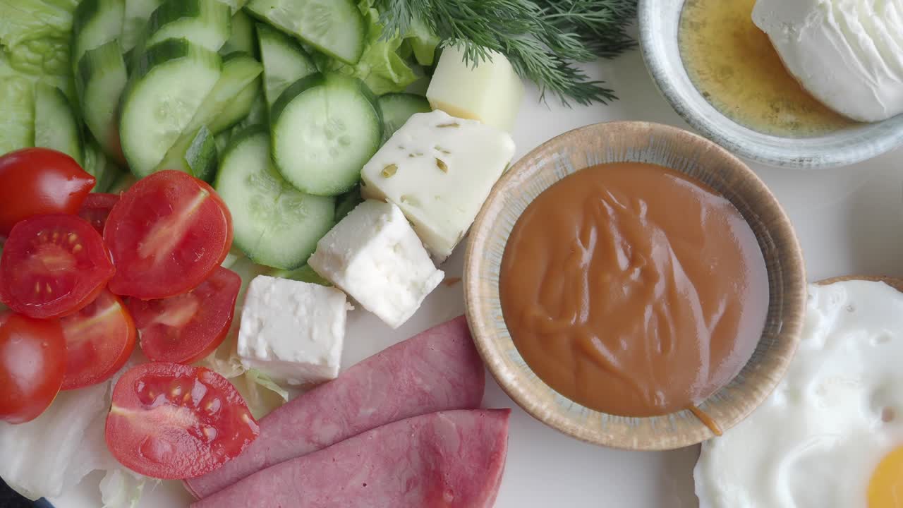 Healthy breakfast with vegetables, cheese, fried egg and jam