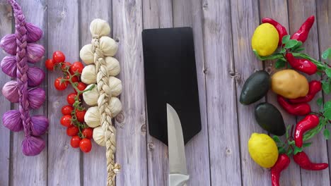 fresh vegetables and fruit on a wooden cutting board with a knife