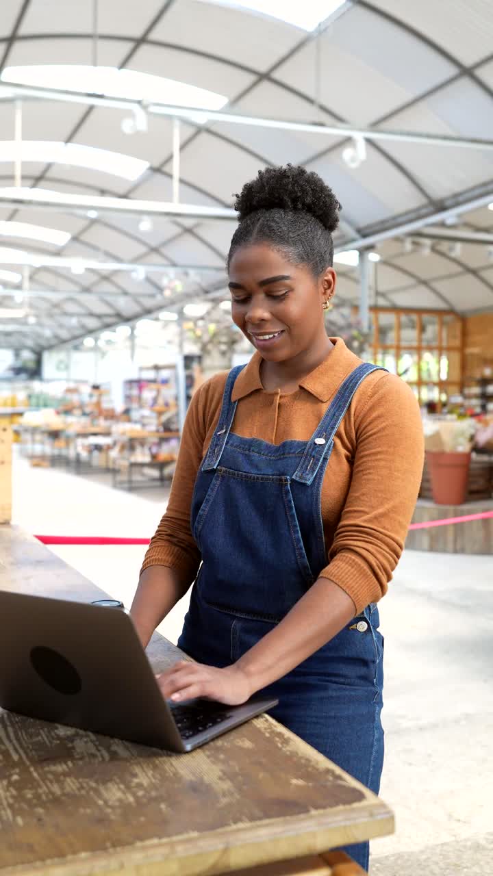 Woman working on laptop in greenhouse