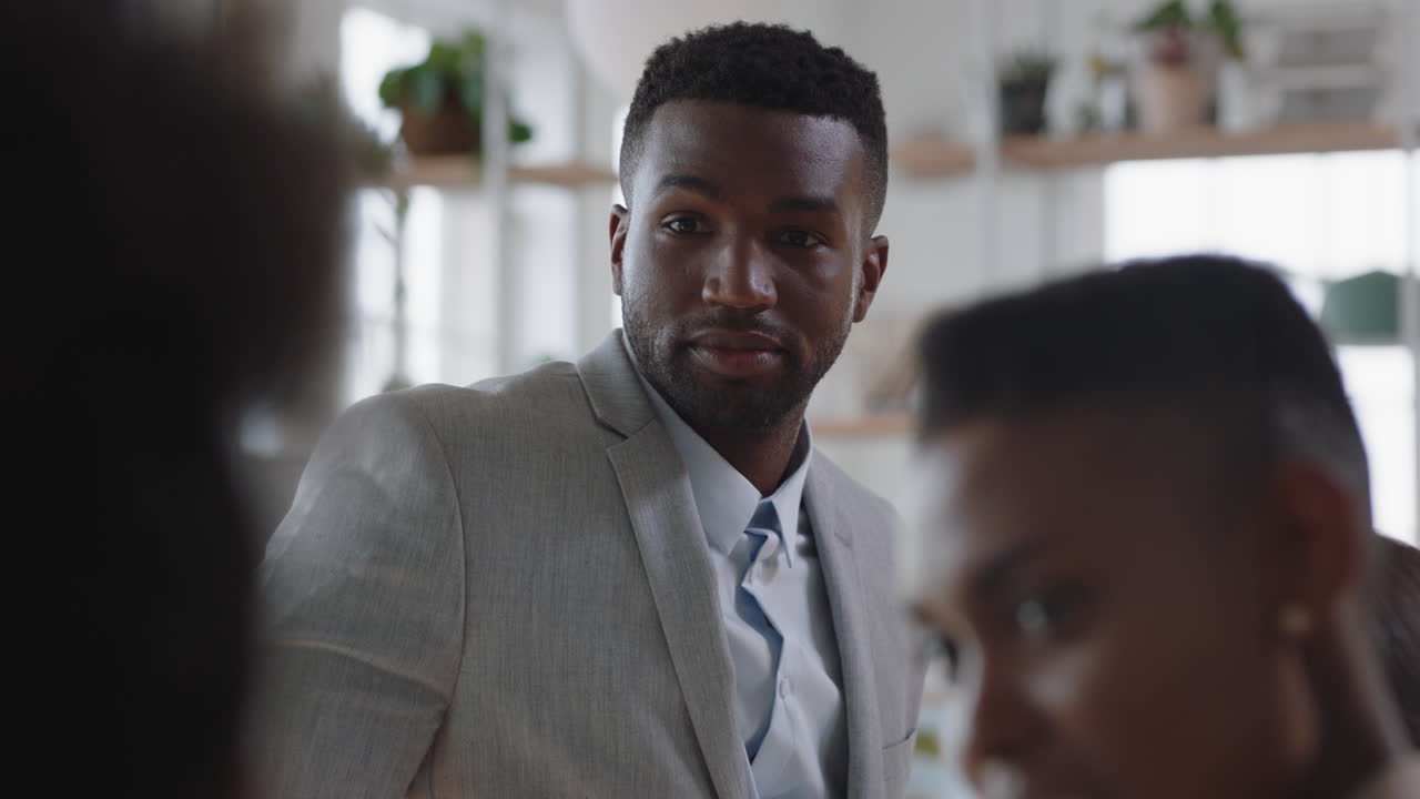 joven empresario afroamericano trabajando con un equipo creativo discutiendo ideas disfrutando del trabajo en equipo en la reunión de la oficina