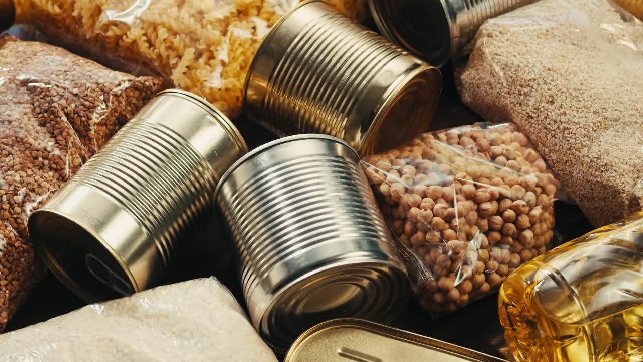 Canned cereals beans fish and vegetables, an assortment of processed foods, supermarket cart online shopping, delivery.