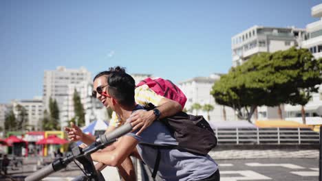 Happy-diverse-gay-male-couple-looking-away-and-pointing-at-promenade-by-the-sea,-slow-motion