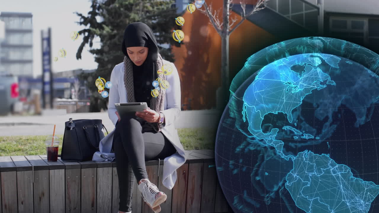 globo y múltiples iconos digitales flotando sobre una mujer en hijab usando una tableta digital en la calle