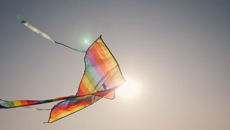 una cometa vuela en los rayos del sol poniente concepto de infancia y sueños