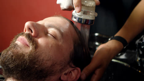 barbero lavando el cabello de los hombres 4k