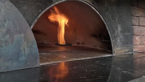 el fuego parpadea dentro de un horno de pizza tradicional.