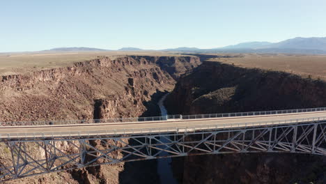 Aéreo-Mientras-Un-Camión-Conduce-Sobre-Un-Profundo-Cañón-Del-Desierto-En-Un-Gran-Puente